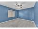 Blue painted bedroom featuring carpet, ceiling fan, and a window at 4116 Free Bird Crest Ave, North Las Vegas, NV 89081