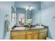 Bathroom featuring a dual sink vanity with granite countertop and a decorative mirror at 4260 E Cincinnati Ave, Las Vegas, NV 89104