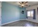 Bedroom with sleek ceiling fan, gray wood-look flooring and a wall painted soft blue at 4260 E Cincinnati Ave, Las Vegas, NV 89104