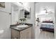 The bright bathroom has a granite-topped vanity and a mirror, with an open doorway to a bedroom with ceiling fan at 4303 E Viking Rd, Las Vegas, NV 89121