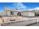 Charming single-story home featuring a stucco exterior, arched entrance, and low-maintenance gravel landscaping at 4303 E Viking Rd, Las Vegas, NV 89121