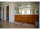 A bathroom featuring double sinks with wood cabinets and a doorway that leads to the toilet at 4384 Grey Spencer Dr, Las Vegas, NV 89141