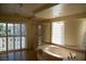 Bright bathroom featuring a large tub, glass shower, and shuttered sliding glass doors to a balcony at 4384 Grey Spencer Dr, Las Vegas, NV 89141