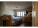 Cozy bedroom featuring a comfortable bed, wooden furniture, and a well-lit window with shutters at 4384 Grey Spencer Dr, Las Vegas, NV 89141