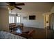 Bright living room featuring a ceiling fan, TV, hardwood floors, and shuttered windows at 4384 Grey Spencer Dr, Las Vegas, NV 89141