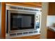 Built-in stainless steel microwave, seamlessly integrated into the wood cabinetry, adding a modern touch to the kitchen at 4384 Grey Spencer Dr, Las Vegas, NV 89141