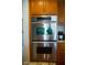 Close up on built-in stainless steel oven with wood cabinets at 4384 Grey Spencer Dr, Las Vegas, NV 89141