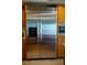 Stainless steel refrigerator, surrounded by wood cabinets, blending functionality with the kitchen's aesthetic at 4384 Grey Spencer Dr, Las Vegas, NV 89141