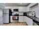 Bright kitchen with stainless steel appliances, white cabinets, and dark countertops at 4505 Providence Ln, Las Vegas, NV 89107