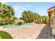 Backyard featuring a pool with waterfall, stone patio, tropical landscaping, and artificial grass at 4542 Grey Spencer Dr, Las Vegas, NV 89141