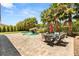 Backyard featuring an outdoor dining area, tropical landscaping, waterfall, and stone patio at 4542 Grey Spencer Dr, Las Vegas, NV 89141