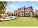 Exterior of house showing back patio with tropical landscaping, putting green, and waterfall at 4542 Grey Spencer Dr, Las Vegas, NV 89141