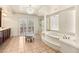 Bright bathroom featuring a jetted tub, glass shower, and elegant chandelier lighting at 4542 Grey Spencer Dr, Las Vegas, NV 89141
