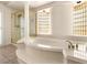 Bright bathroom featuring a jetted tub, glass shower, and elegant finishes at 4542 Grey Spencer Dr, Las Vegas, NV 89141