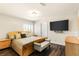 Bedroom featuring wood floors, mounted tv, and a bench at the foot of the bed at 4542 Grey Spencer Dr, Las Vegas, NV 89141