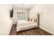 Cozy bedroom with plantation shutters, wood floors, and a plush upholstered bed at 4542 Grey Spencer Dr, Las Vegas, NV 89141