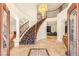 Grand foyer showcases a sweeping staircase, tiled floors, and elegant chandelier at 4542 Grey Spencer Dr, Las Vegas, NV 89141