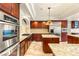 Well-equipped kitchen with stainless steel appliances, granite countertops, custom cabinetry, and center island at 4542 Grey Spencer Dr, Las Vegas, NV 89141