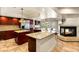 Spacious kitchen featuring stainless steel appliances, ample counter space, and a cozy fireplace at 4542 Grey Spencer Dr, Las Vegas, NV 89141