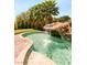 Resort-style pool featuring a rock waterfall and lush palm trees at 4542 Grey Spencer Dr, Las Vegas, NV 89141