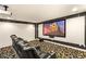 Home theater with a large screen, projector, black leather seats, and patterned carpet at 4542 Grey Spencer Dr, Las Vegas, NV 89141