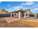 View of the house and covered patio in the backyard with desert landscaping and black brick fence at 4769 Via Renaldo, Las Vegas, NV 89103