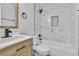 Bathroom featuring marble tile surround, modern vanity with wood accents, and black fixtures at 4769 Via Renaldo, Las Vegas, NV 89103