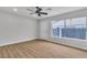 Spacious living room with wood-look flooring, ceiling fan, and large window providing plenty of natural light at 4769 Via Renaldo, Las Vegas, NV 89103