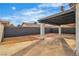 A covered patio area with a concrete slab and red brick extension surrounded by desert landscaping at 4769 Via Renaldo, Las Vegas, NV 89103