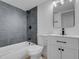 Bathroom featuring a tub with gray tile surround, modern vanity, and stylish fixtures at 4825 Randall Dr, Las Vegas, NV 89122