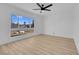 Bedroom with light wood floors, a ceiling fan, and a large window overlooking the street at 4825 Randall Dr, Las Vegas, NV 89122