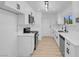 White kitchen with stainless appliances, white countertops, and light wood floors at 4825 Randall Dr, Las Vegas, NV 89122