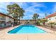 Community pool with clear blue water, surrounded by lush landscaping and apartment buildings at 5326 Swenson St # 61, Las Vegas, NV 89119