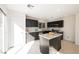 Stylish kitchen with dark cabinetry, stainless steel appliances, tile flooring, and a granite-topped island for modern living at 5357 Hammond Ct, Las Vegas, NV 89110