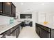 Spacious kitchen featuring dark cabinets, stainless steel appliances, a center island, and plenty of counter space for cooking at 5357 Hammond Ct, Las Vegas, NV 89110