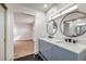 Elegant bathroom boasts a double sink vanity, round mirrors, and sleek black floor tiling at 5825 Bent Branch Ln, Las Vegas, NV 89142