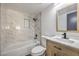 Cozy bathroom featuring modern tile, a shower-tub combo, and a wood-grained vanity with quartz countertop at 5825 Bent Branch Ln, Las Vegas, NV 89142