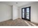 Well-lit bedroom with neutral carpet, a closet, and black French doors to a balcony at 5825 Bent Branch Ln, Las Vegas, NV 89142