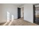 Bright bedroom featuring neutral carpet, white walls, and a dark-colored door leading to the staircase at 5825 Bent Branch Ln, Las Vegas, NV 89142