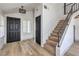 Bright entryway with wood-look floors, staircase, black front door, and natural light throughout at 5825 Bent Branch Ln, Las Vegas, NV 89142