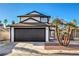 Charming two-story home showcasing a well-maintained front yard and a spacious two-car garage under a clear blue sky at 5825 Bent Branch Ln, Las Vegas, NV 89142