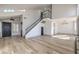 Open-concept living room with modern wood flooring, staircase, and bright, natural light at 5825 Bent Branch Ln, Las Vegas, NV 89142