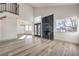 Sun-filled living room features high ceilings, wood-look flooring, and a modern fireplace with black marble accents at 5825 Bent Branch Ln, Las Vegas, NV 89142