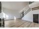 Bright and open living room with modern flooring, high ceilings, and staircase with metal railing at 5825 Bent Branch Ln, Las Vegas, NV 89142