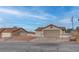 Street view of a single-story home featuring a two-car garage and long driveway at 613 W Victory Rd, Henderson, NV 89015