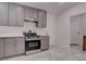 Kitchen featuring gray cabinets, stainless steel oven, and access to the entry area at 613 W Victory Rd, Henderson, NV 89015