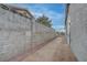 Long side yard with concrete walkway and rock landscaping, enclosed by a block wall at 613 W Victory Rd, Henderson, NV 89015