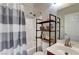 Bright bathroom featuring a shower-tub combo, modern vanity, and industrial-style shelving at 6320 Desert Leaf St # 101, North Las Vegas, NV 89081