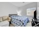 Inviting bedroom featuring a bed with blue and white patterned comforter and a cozy chair near the window at 6320 Desert Leaf St # 101, North Las Vegas, NV 89081