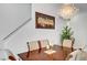 Dining area with a chandelier, hardwood table, and upholstered chairs beneath staircase art at 6320 Desert Leaf St # 101, North Las Vegas, NV 89081